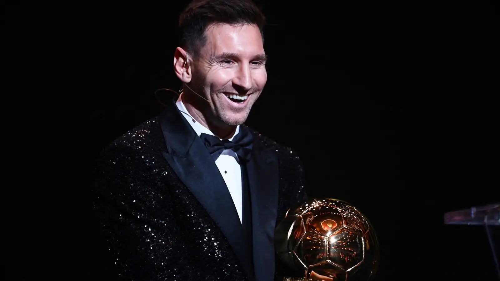 Lionel Messi in a sequinned jacket smiling with his seventh Ballon d'Or