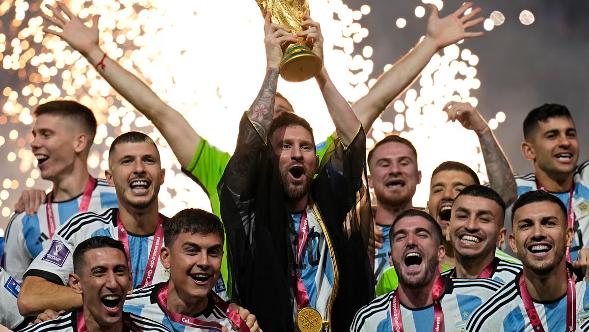 Lionel Messi lifting the World Cup trophy surrounded by celebrating teammates and fireworks