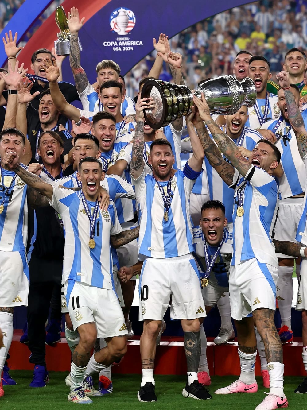 Lionel Messi lifting the Copa América trophy surrounded by celebrating Argentina teammates
