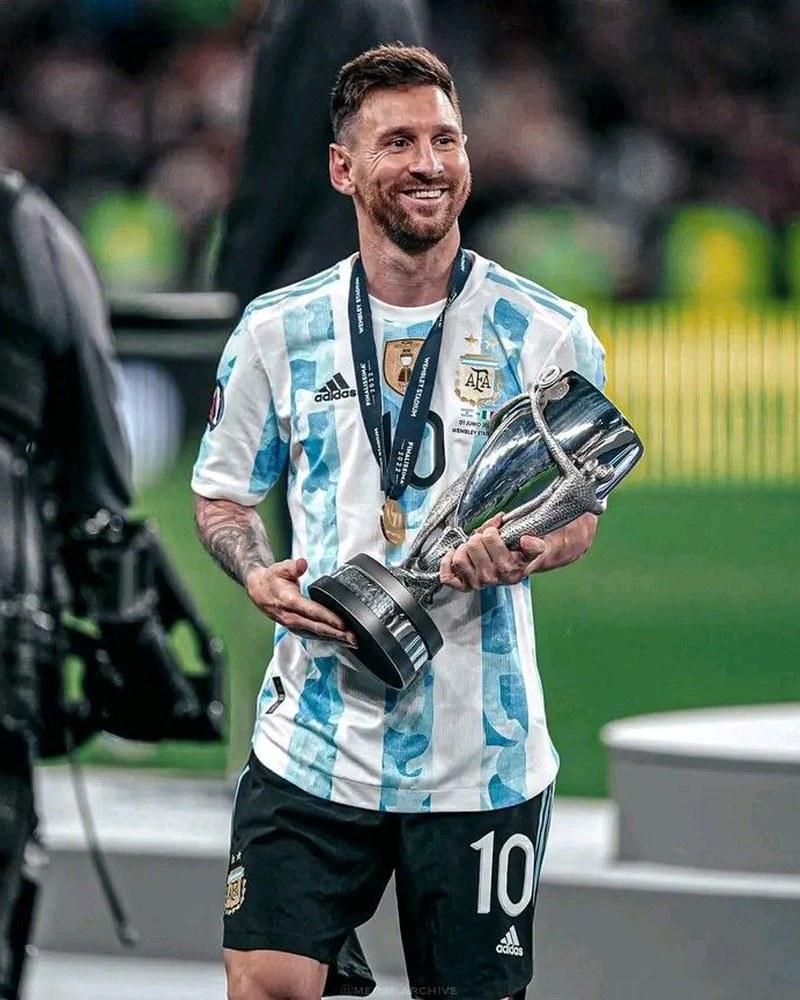 Lionel Messi smiling and holding the Finalissima trophy at Wembley