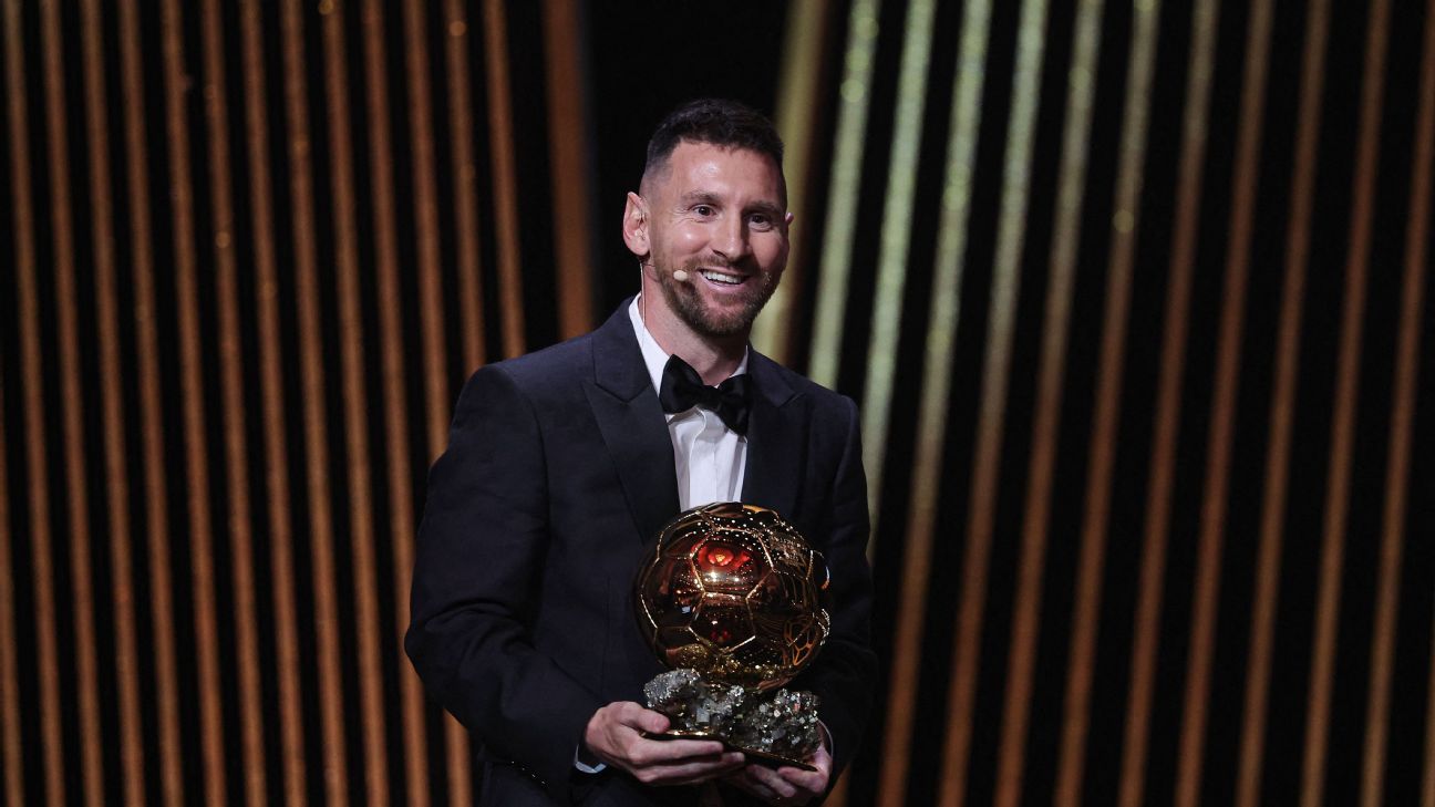 Lionel Messi in a tuxedo holding his eighth Ballon d'Or on stage